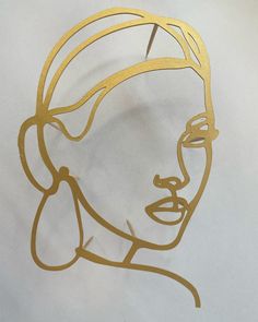 a golden metal face on a white background with the word beauty written in gold foil