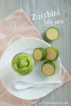 a white plate topped with cucumbers next to a cup of baby puree