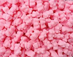 a pile of pink colored marshmallows sitting on top of a white table