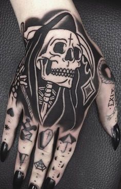 a tattooed hand with a skull and cross on it