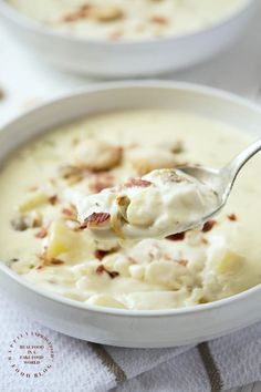 a spoonful of potato soup with bacon and cream in a white bowl on a table