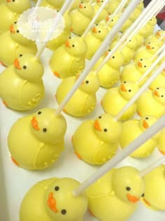 many yellow rubber ducks are lined up on a table with chopsticks in their mouths