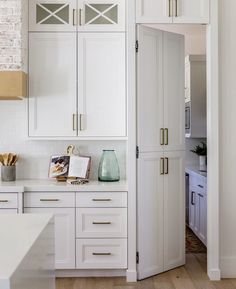 a kitchen with white cabinets and wooden floors