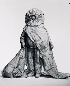 a black and white photo of a man in a suit with an umbrella over his head