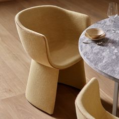 a table with two chairs and a wine glass on the top, next to each other