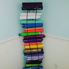 a stack of different colored papers sitting on top of a white floor next to a wall