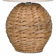 a wicker table lamp with a white shade on the top, and a beige linen shade on the bottom