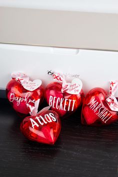 red heart shaped candies sitting next to each other on a black table with white lettering