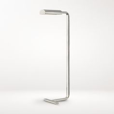 a lamp that is on top of a white surface and has a metal pole attached to it