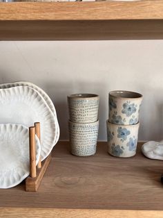 plates and cups are sitting on a shelf