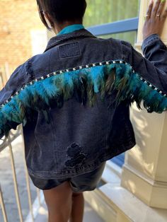 Black denim jacket with turquoise feathers lining the back seam along the arms and back. Stud detailing also lines the back of the jacket. Fits Both a size small and medium. Jacket is a relaxed fit with pockets. Some distressing on the back. Cut Up Shirts, Black Peacock, Diy Denim, Feather Jacket, Jacket Fits, Womens Jackets, Blue Jean Jacket