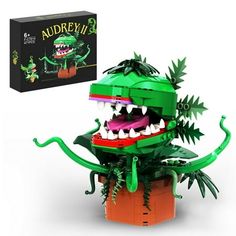 a lego model of an alligator with its mouth open and teeth wide open, sitting in front of a box