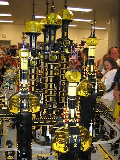 a group of people looking at a model of a city made out of legos