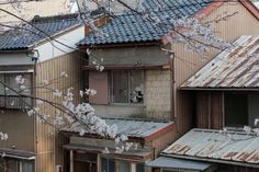 an old building with lots of windows and tin roofing on the side of it