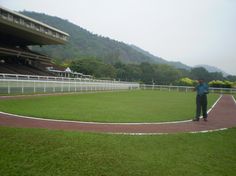 a man standing in front of a horse track