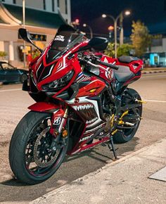 a red and black motorcycle parked on the street