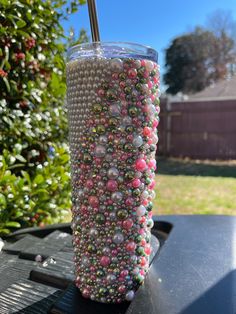 a cup filled with beads and a straw sticking out of it's side on top of a table