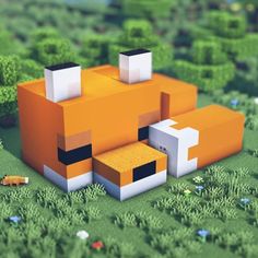 an orange and white animal sitting on top of a lush green field