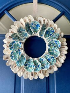 a blue door with a white and green wreath hanging on it's front door