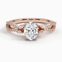 a rose gold engagement ring with an oval cut diamond in the center and two rows of diamonds on each band