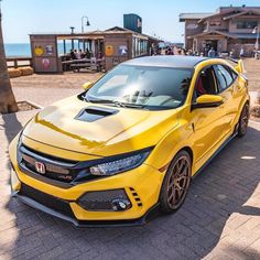 a yellow car parked in front of the ocean