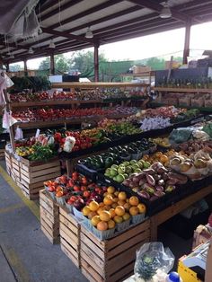 an outdoor market with fruits and vegetables on display