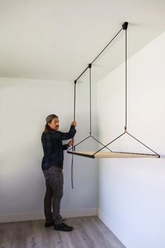 a man is hanging something from the ceiling