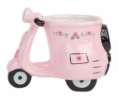 a pink scooter shaped planter with flowers on the front and side wheels