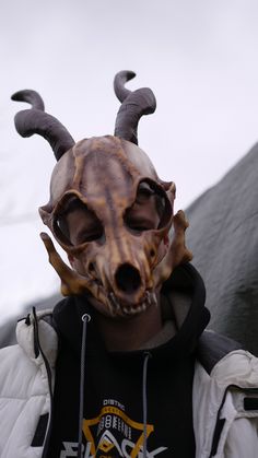 a man wearing an animal mask with horns on his head