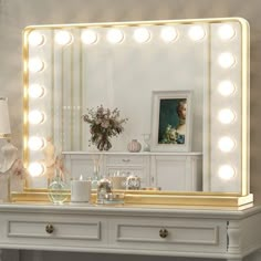 a white dresser topped with a mirror and lights