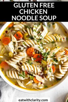 a bowl of chicken noodle soup with carrots and parsley