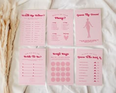 four pink wedding games are laid out on a white sheet with some dried grass next to it