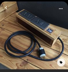 a couple of black wires sitting on top of a wooden table next to a box