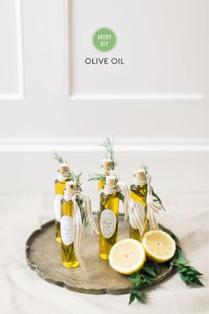 three bottles of olive oil with lemons on a tray