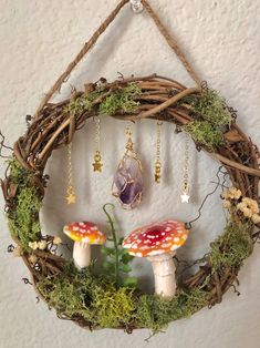 a wreath with two mushrooms hanging from it's side and moss growing on the outside