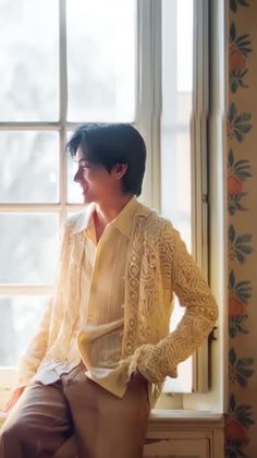 a woman sitting on top of a window sill next to a window pane