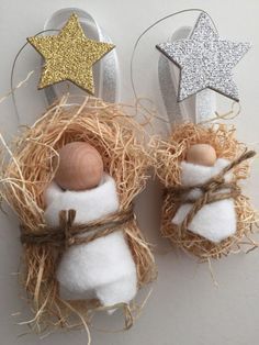 two snowmen are placed next to each other in a nest with straw and star decorations