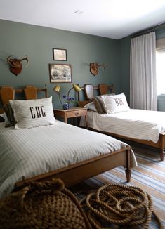 two twin beds in a room with blue walls and striped rugs on the floor