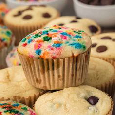 cupcakes with sprinkles and chocolate chips on top are stacked up