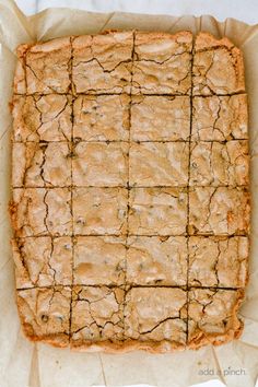 a square brownie sitting on top of a piece of parchment paper