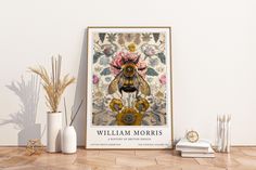 a poster with a bee on it next to some vases and plants in front of a white wall