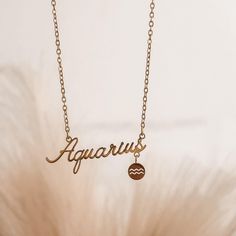 a gold necklace with the word aquarius on it