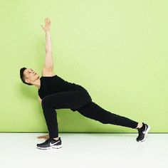 a woman in black shirt and leggings standing on one leg with her hand up