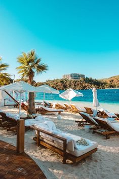 lounge chairs and umbrellas are on the beach