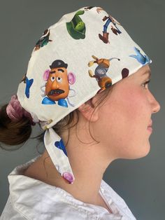 a woman wearing a white hat with cartoon characters on it's side and her hair in a pony tail