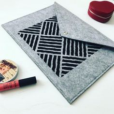 a macbook pro case sitting on top of a table next to some lipstick and other items