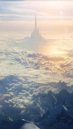 an aerial view of a castle in the sky with clouds and mountains around it,