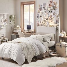 a bedroom with white bedding and lots of pictures on the wall next to it