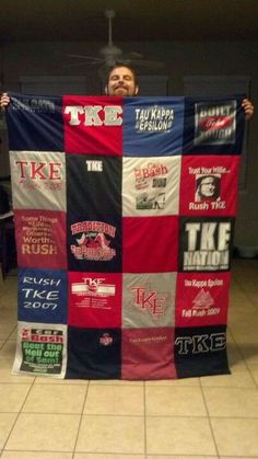 a man is holding up a quilt made with t - shirts and other things on it