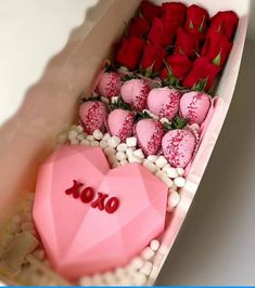 a box filled with lots of red and white flowers next to a heart shaped object